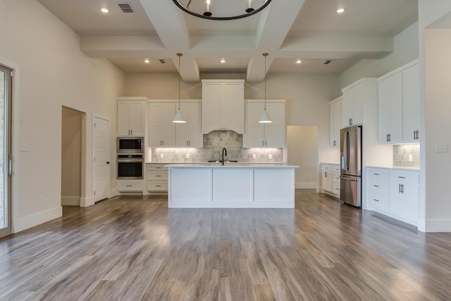 4603 140th St, Lubbock, TX 79424 - kitchen featuring appliances with stainless steel finishes, tasteful backsplash, light countertops, wood finished floors, and coffered ceiling
