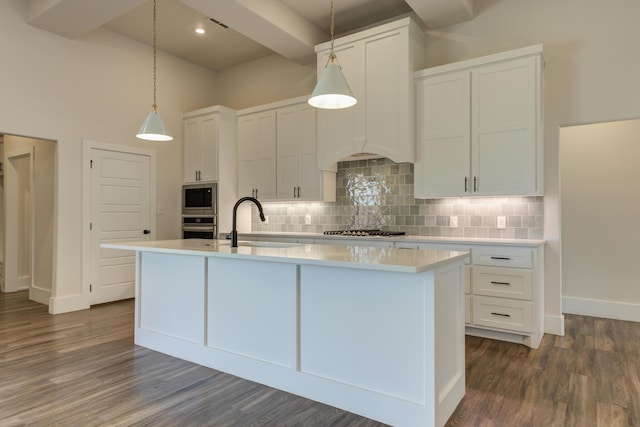 4603 140th St, Lubbock, TX 79424 - kitchen with appliances with stainless steel finishes, light countertops, decorative backsplash, a center island with sink, and a towering ceiling