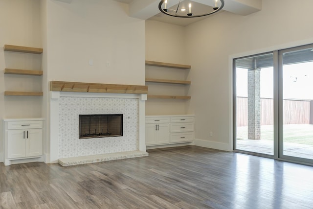 4603 140th St, Lubbock, TX 79424 - unfurnished living room featuring wood finished floors, a fireplace, a chandelier, and built in shelves