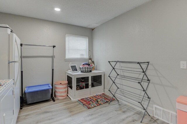 interior space featuring light hardwood / wood-style floors and a textured ceiling