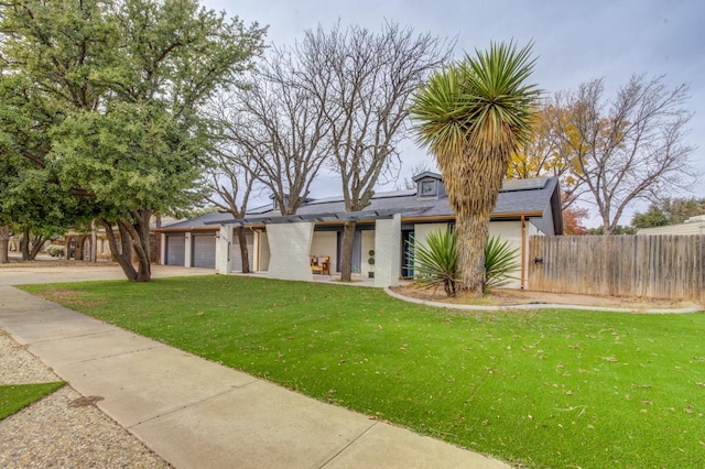 view of front of property with a garage and a front lawn