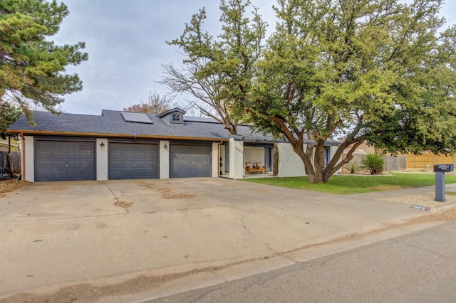 view of front of home featuring a garage and solar panels