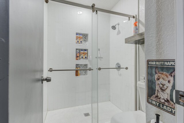 bathroom featuring toilet and an enclosed shower