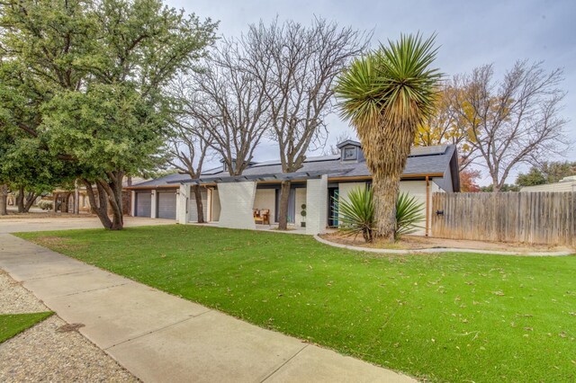 view of front of house with a garage and a front lawn