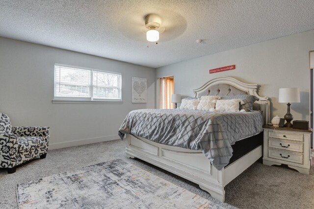 carpeted bedroom featuring ceiling fan and a textured ceiling