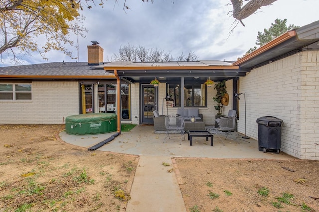 back of house featuring an outdoor living space and a patio area