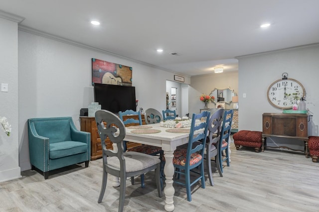 dining area with crown molding and light wood-type flooring