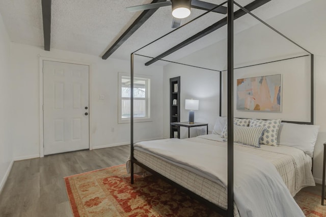 bedroom with a textured ceiling, wood finished floors, a ceiling fan, and baseboards