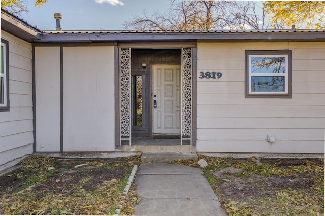 doorway to property featuring metal roof