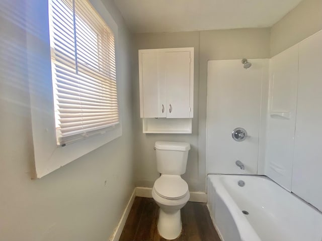 bathroom with hardwood / wood-style floors, bathing tub / shower combination, and toilet