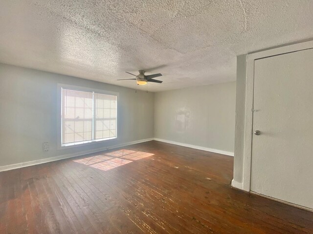 unfurnished room featuring ceiling fan, a textured ceiling, and dark hardwood / wood-style flooring