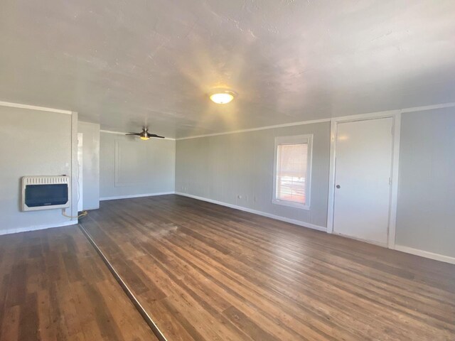 unfurnished living room with heating unit, a fireplace, dark wood-type flooring, and ceiling fan