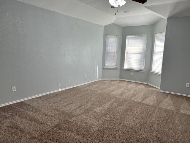 unfurnished room featuring ceiling fan, lofted ceiling, and carpet flooring