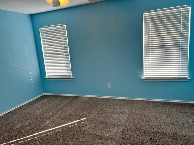 carpeted empty room featuring ceiling fan