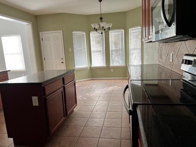 kitchen featuring a kitchen island, pendant lighting, light tile patterned floors, an inviting chandelier, and stainless steel electric range