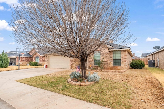 view of front of home with central AC, a garage, and a front yard