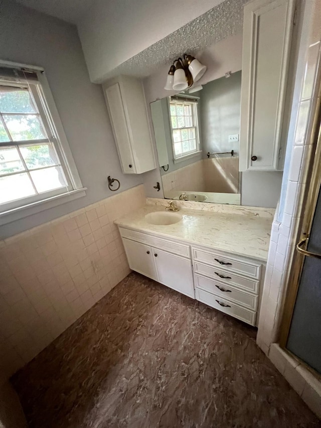 bathroom featuring vanity and tile walls