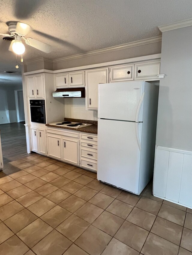 kitchen featuring white cabinetry, crown molding, a textured ceiling, ceiling fan, and white appliances