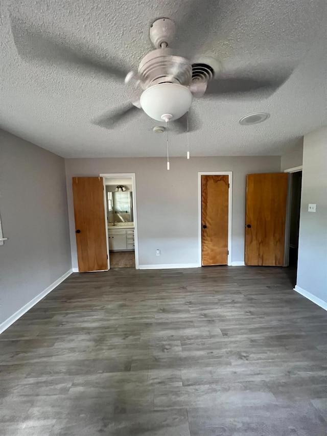 unfurnished room with a textured ceiling, wood-type flooring, and ceiling fan