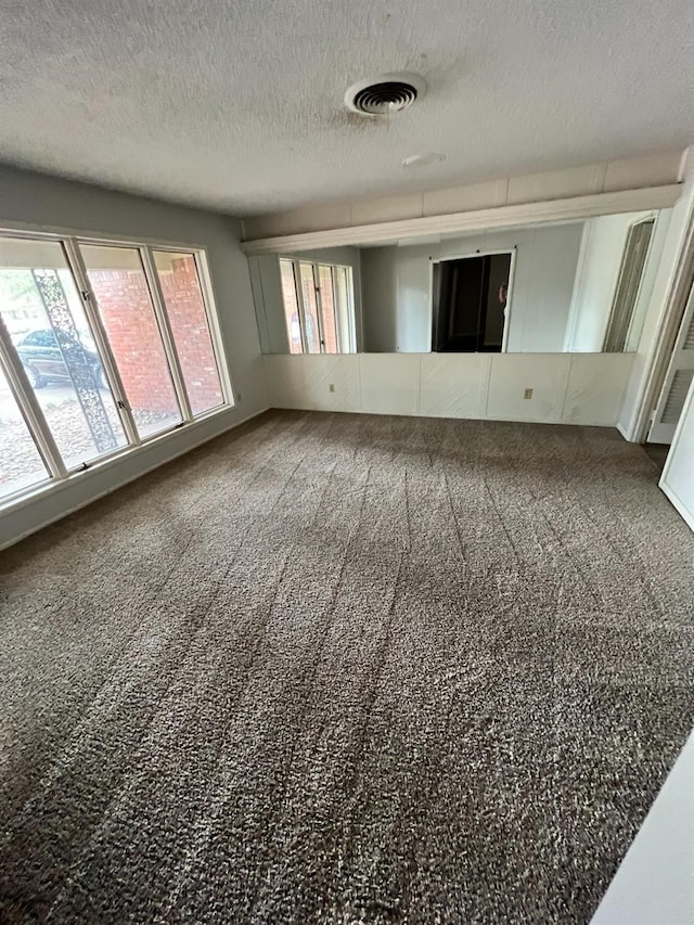 carpeted spare room featuring a textured ceiling