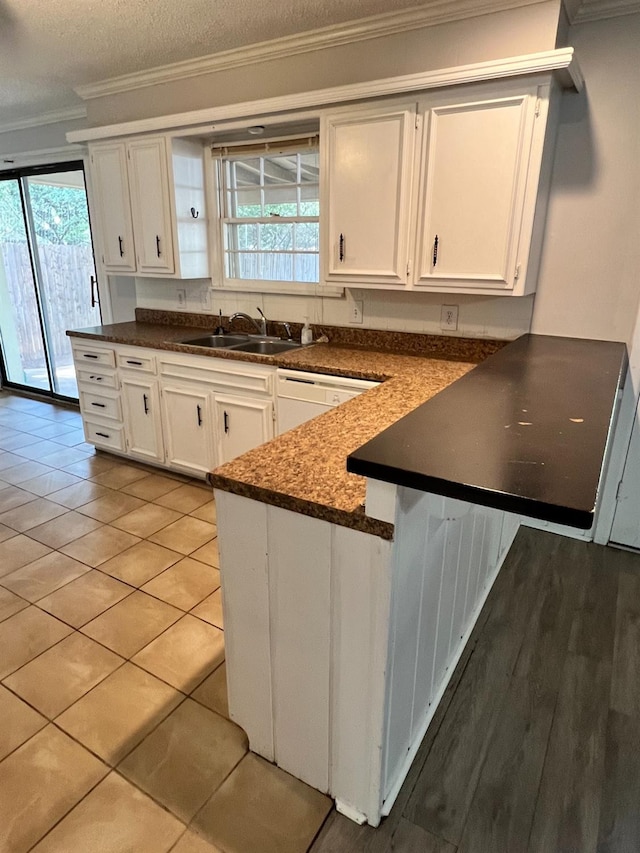 kitchen with sink, dishwasher, ornamental molding, a healthy amount of sunlight, and white cabinets