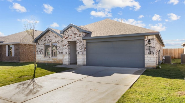 ranch-style home featuring cooling unit, a garage, and a front yard