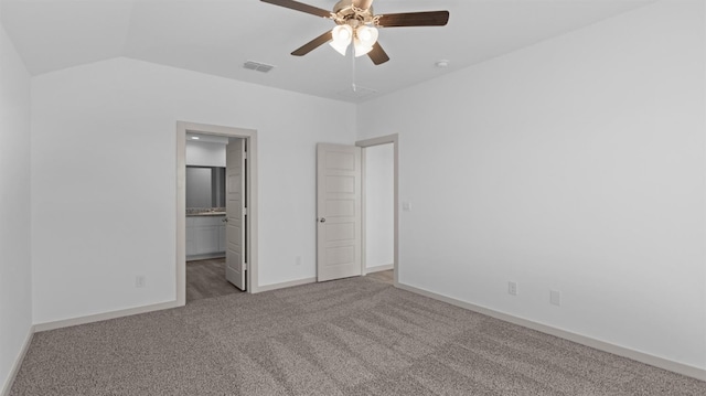 unfurnished bedroom featuring ensuite bath, carpet floors, ceiling fan, and vaulted ceiling