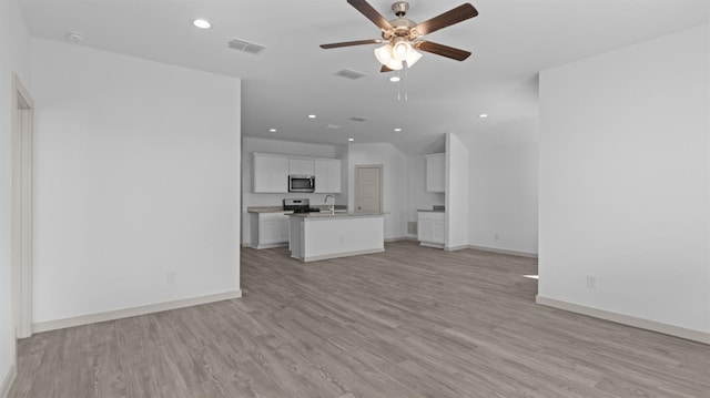 unfurnished living room with ceiling fan, sink, and light hardwood / wood-style floors