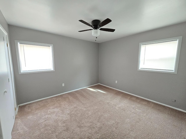 unfurnished room with ceiling fan, plenty of natural light, and light carpet