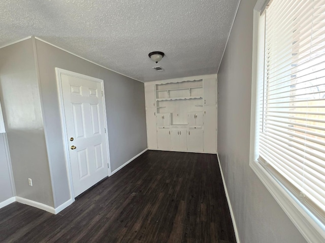 hallway featuring a textured ceiling and dark hardwood / wood-style flooring