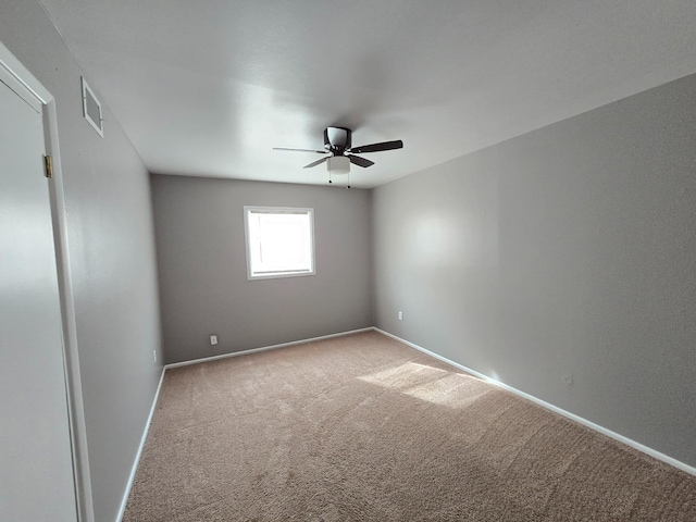 carpeted spare room with ceiling fan