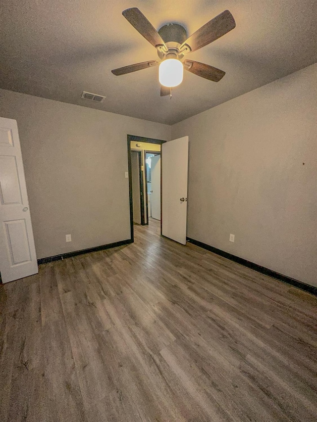 empty room with a textured ceiling, wood-type flooring, and ceiling fan