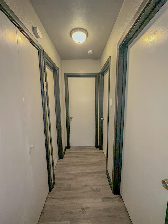 hallway with light hardwood / wood-style floors