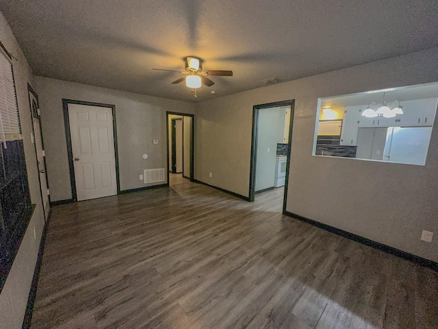 unfurnished living room featuring hardwood / wood-style flooring, ceiling fan with notable chandelier, and a textured ceiling