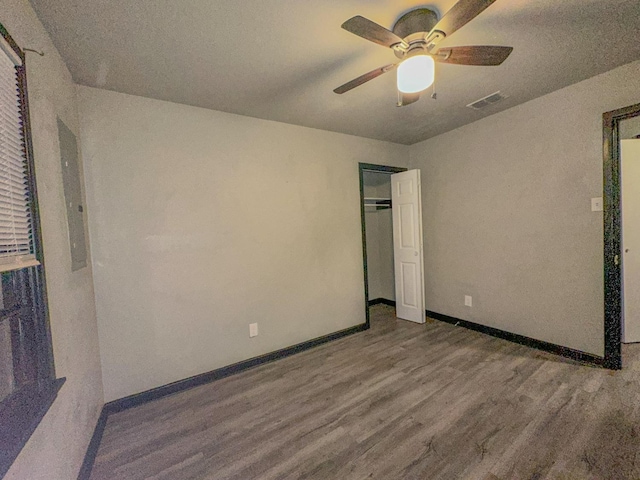 unfurnished bedroom with hardwood / wood-style flooring, ceiling fan, and a closet