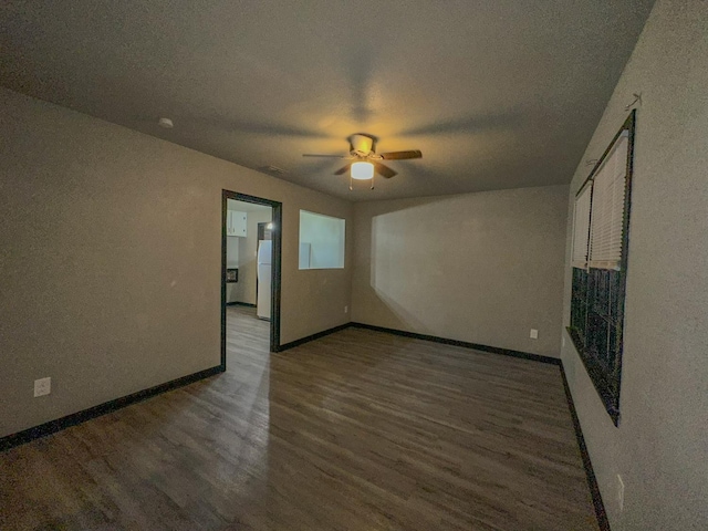 unfurnished room with ceiling fan, dark wood-type flooring, and a textured ceiling