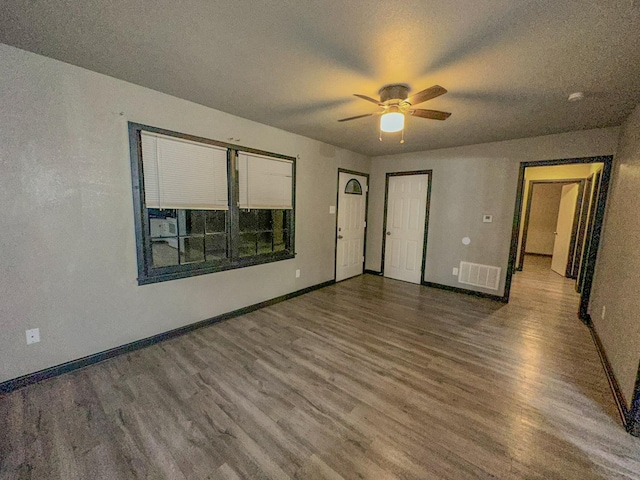 spare room with hardwood / wood-style flooring, ceiling fan, and a textured ceiling