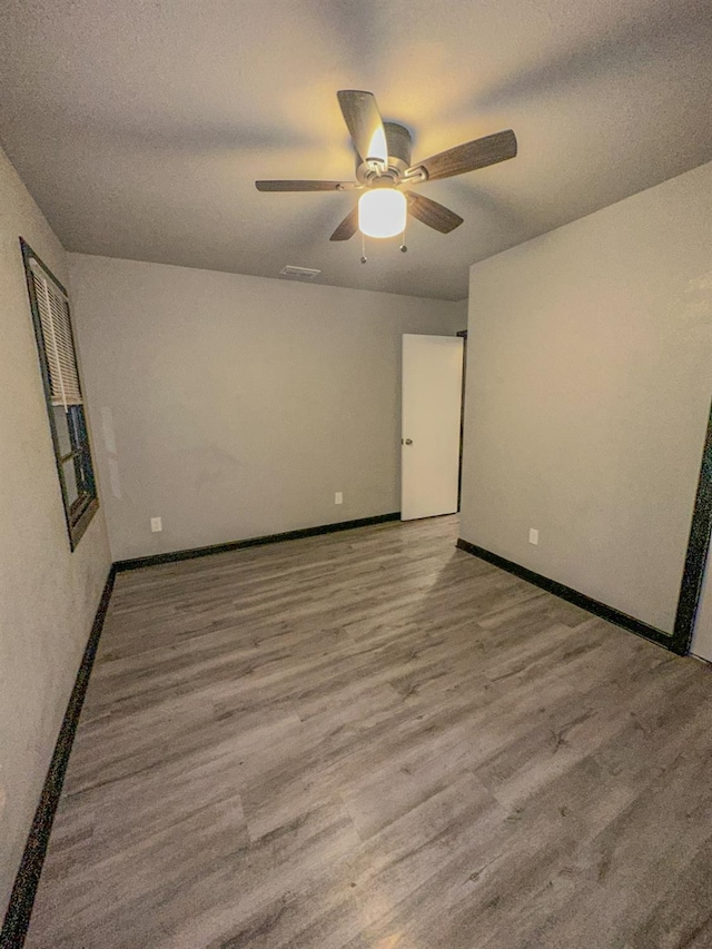 empty room with ceiling fan, light hardwood / wood-style floors, and a textured ceiling