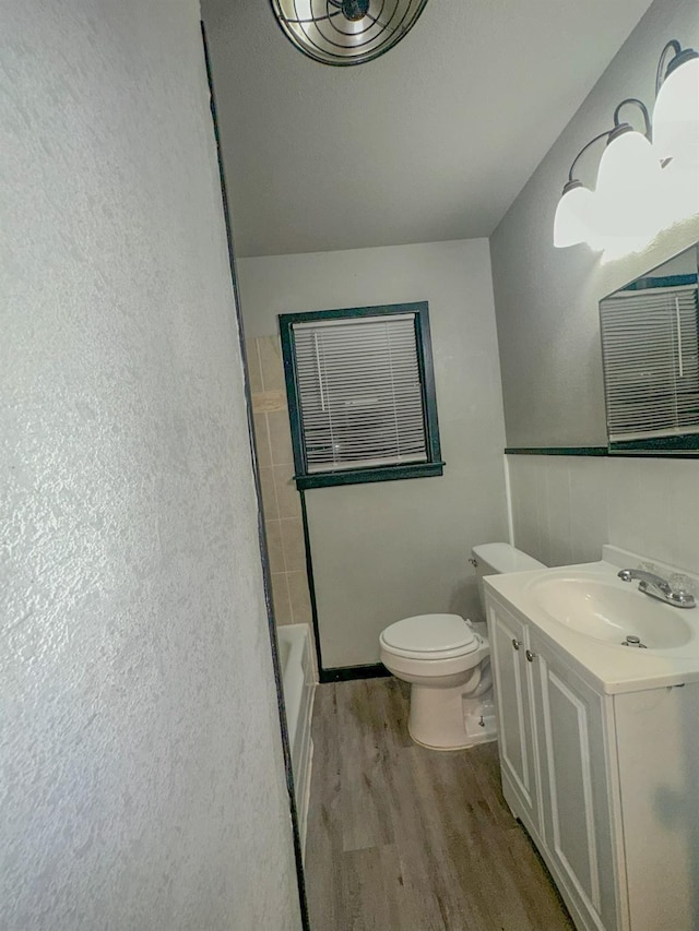 full bathroom with vanity, hardwood / wood-style flooring, independent shower and bath, and toilet