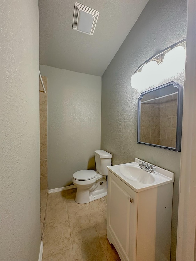 bathroom featuring vanity, tile patterned flooring, a textured ceiling, and toilet