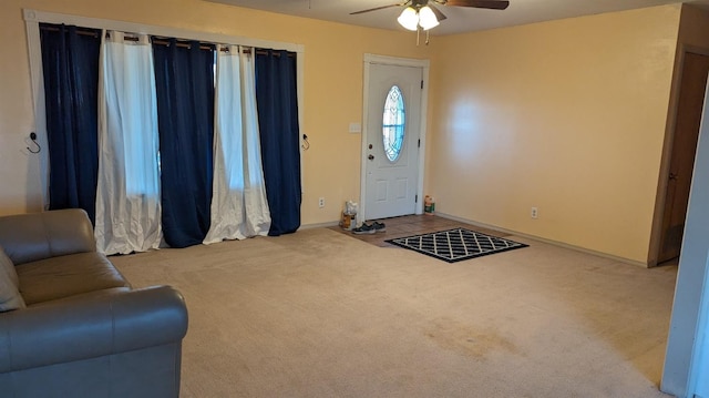 carpeted entryway with ceiling fan