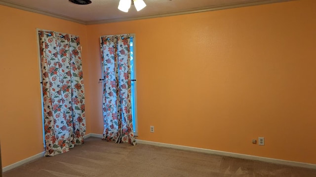 empty room with crown molding and carpet flooring