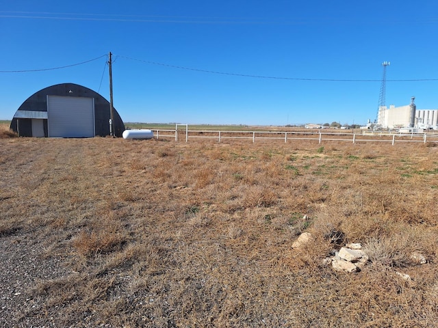 view of yard featuring a garage and a rural view