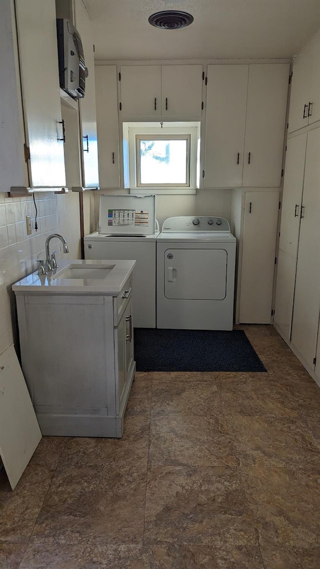 laundry area with cabinets, washer / dryer, and sink