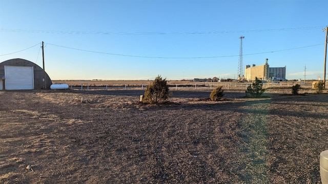 view of yard featuring a garage and a rural view