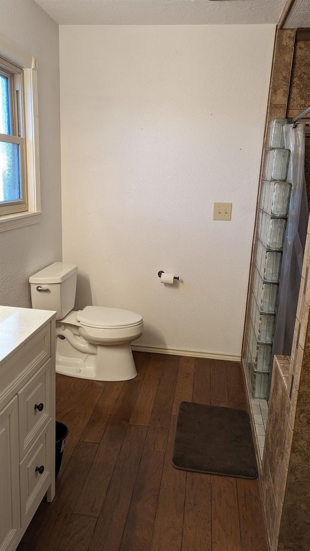 bathroom with vanity, toilet, wood-type flooring, and a shower