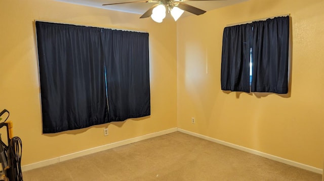 carpeted spare room featuring ceiling fan