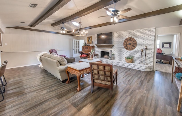 living room with ceiling fan with notable chandelier, vaulted ceiling with beams, dark wood-type flooring, and a fireplace