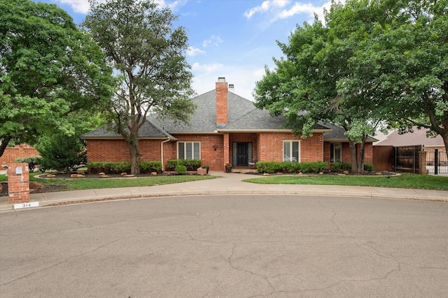 314 York Ave, Lubbock, TX 79416 - view of front of house featuring brick siding, roof with shingles, and a chimney
