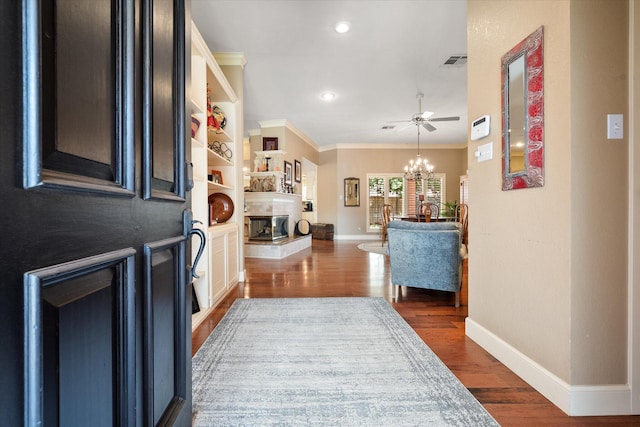 314 York Ave, Lubbock, TX 79416 - foyer with ornamental molding, a chandelier, dark wood-style flooring, recessed lighting, and a fireplace
